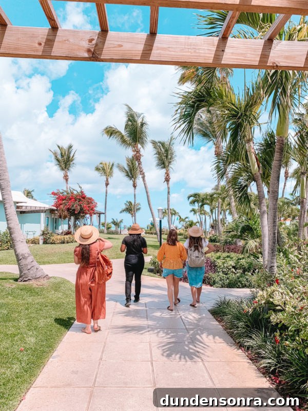 Beaches Turks and Caicos Review: Tips for Traveling with Toddlers 6 A group of people walking down a sidewalk next to a palm tree