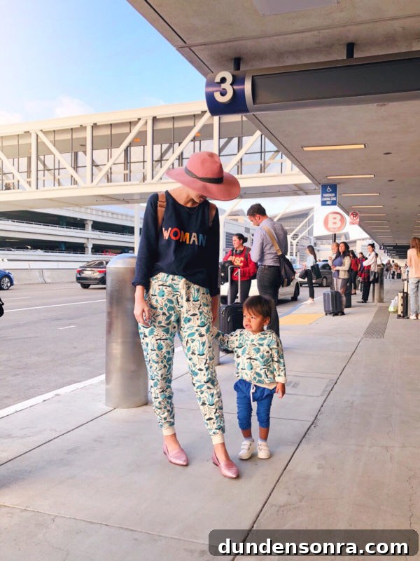 Flying With a Baby or Toddler: Tips, Gear & Plane Activities 2 Two people standing at an airport