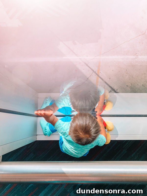 Flying With a Baby or Toddler: Tips, Gear & Plane Activities 3 A boy next to glass