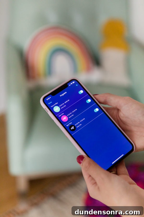 Hatch Baby Rest+ Review and Smart Sleep Tips for New Parents 5 Someone holding a phone