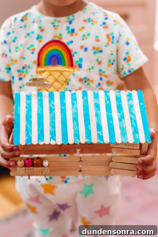 A person holding a popsicle house