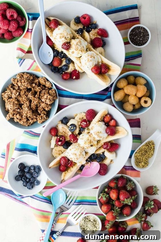 Favorite Breakfast Recipes Our Family Loves 12 Breakfast Banana Split with bowls of granola and berries on a striped towel