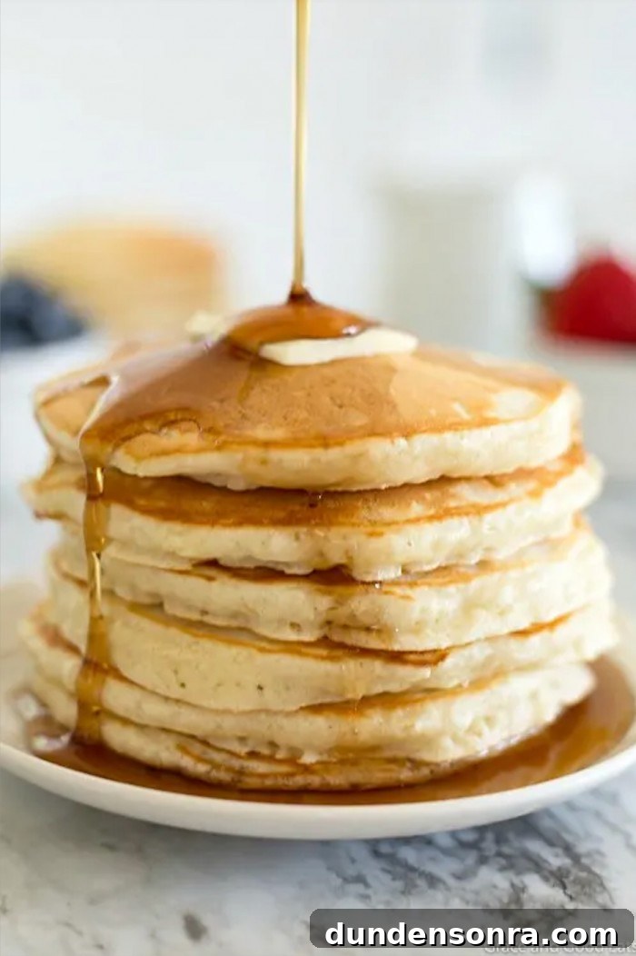 Favorite Breakfast Recipes Our Family Loves 5 Stack of pancakes with syrup being poured over it