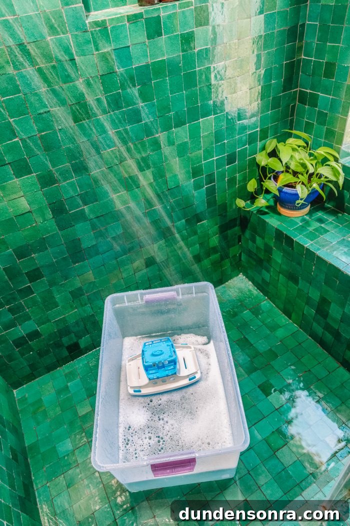 A green tiled shower with a bucket