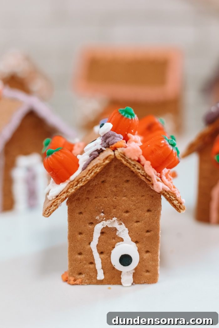 Edible Haunted Houses: Halloween Candy House Ideas and Guide 19 A house made of graham crackers with small pumpkins on the roof