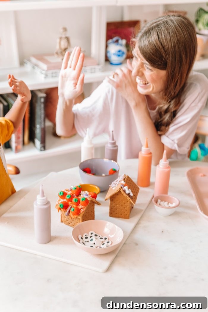 Edible Haunted Houses: Halloween Candy House Ideas and Guide 20 Someone sitting at a table making graham cracker houses