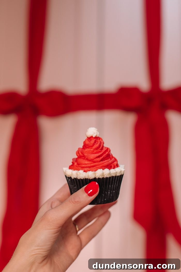 Santa Hat Cupcakes: Festive Holiday Recipe for Homemade Treats 2 A person holding a Santa hat cupcake