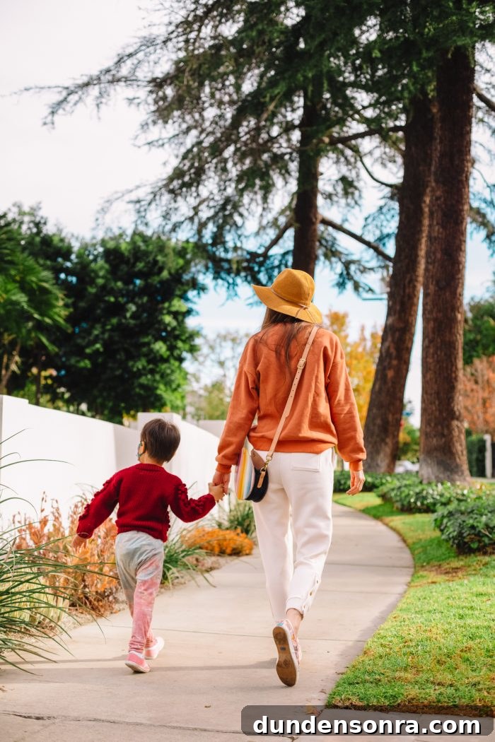A boy and woman walking on a sidewalk