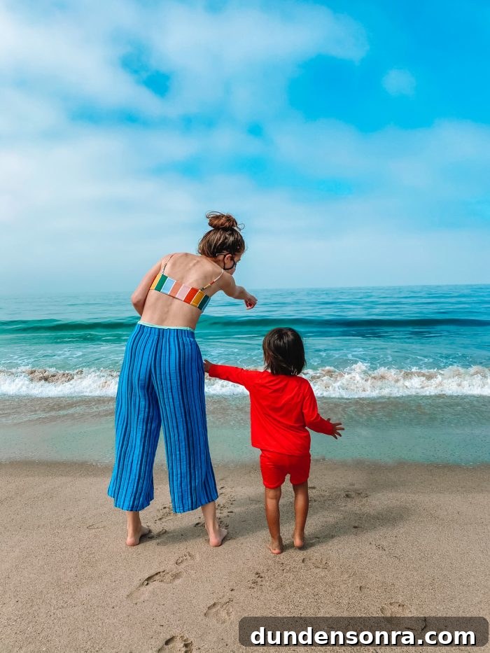 A boy and a woman standing on a beach