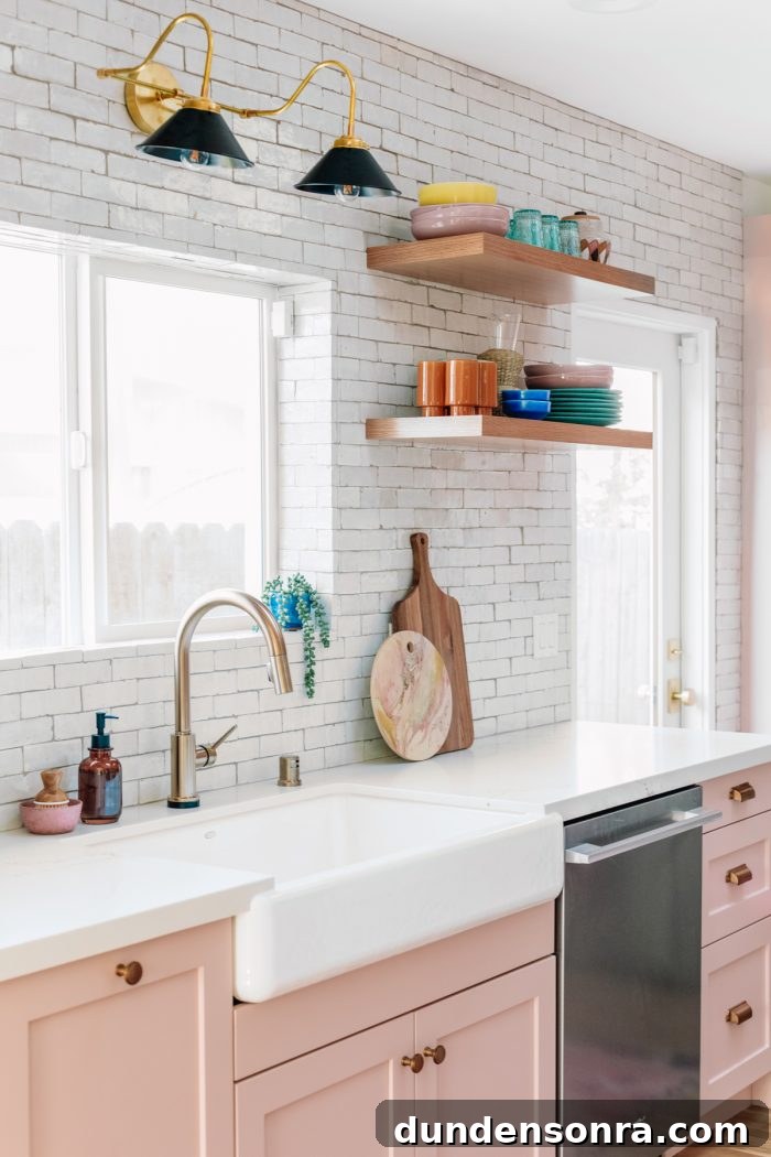 Sustainable Paper Towel Alternatives: Practical Ways to Eliminate Disposable Towels 7 White tile kitchen with light pink cabinets and colorful glassware on floating shelves