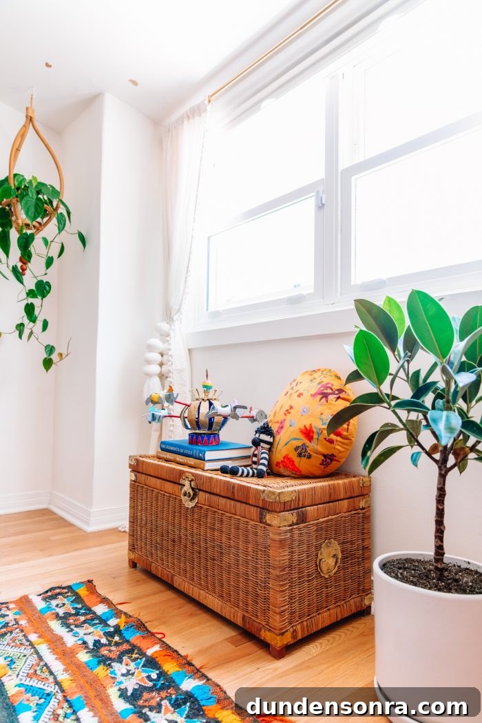 Create a Stylish Home Office and Guest Room: Design Tips for a Multipurpose Space 17 wicker trunk with pillow and books on top under a window next to two plants and a colorful moroccan rug