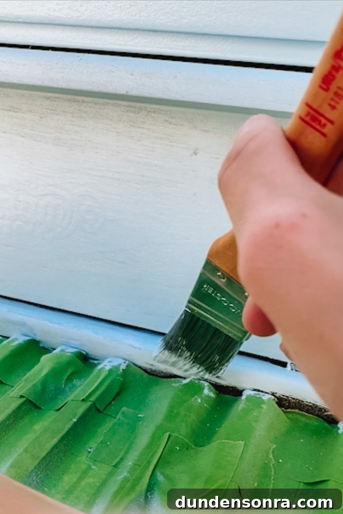 Paint brush touch ups on painted piano with piano keys covered in painter's tape