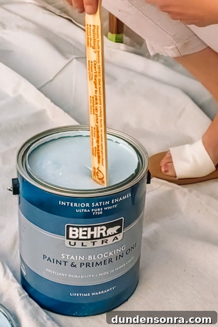 Can of blue BEHR Paint being stirred