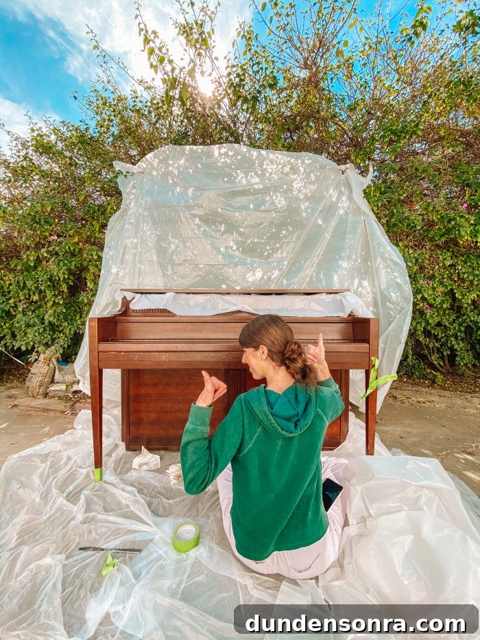 Wood piano in front of plastic tarp