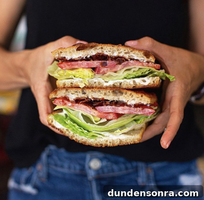 Top Sandwich Spots in Los Angeles: Where Locals Go 8 BLT stacked and held in two hands in front of a black shirt