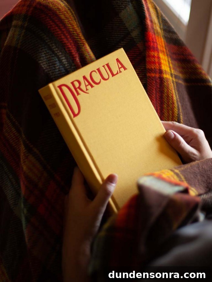 Top Halloween Home Decor Ideas to Transform Your Space 15 Hands holding Yellow Dracula book over a plaid blanket
