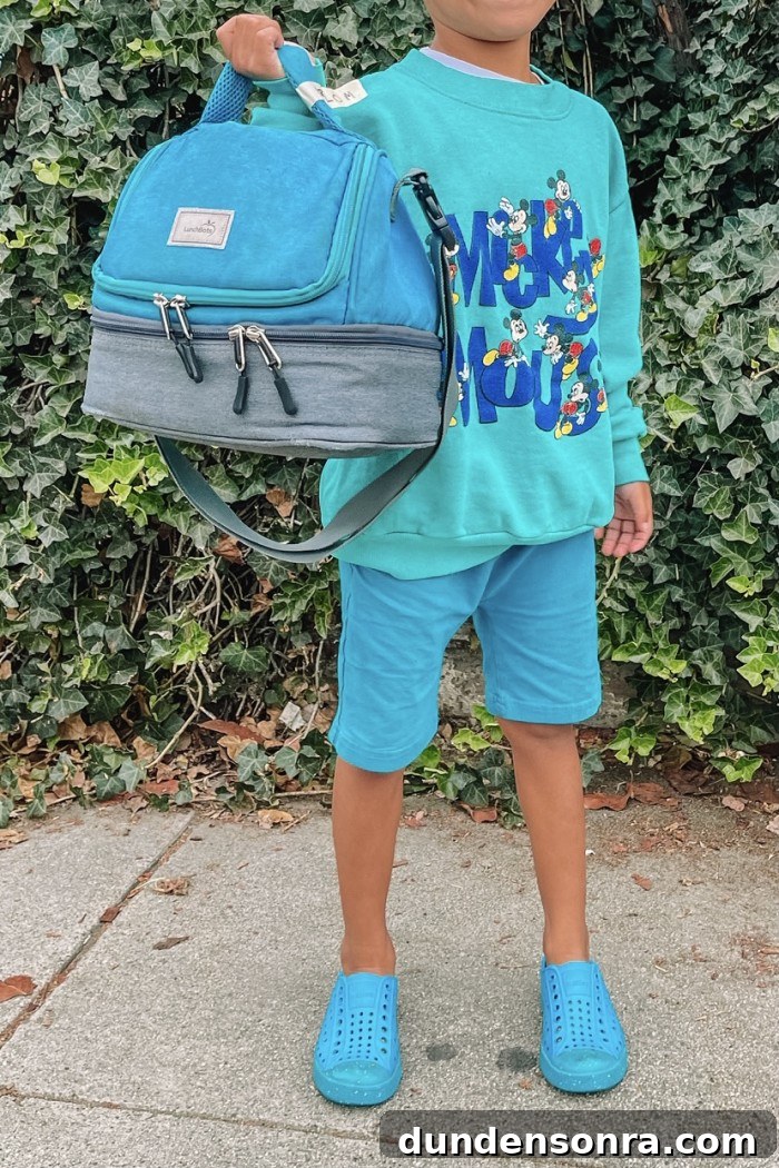 Preschool Lunch and Classroom Essentials: What Every Parent Needs 3 child wearing turquoise blue holding a lunch bag