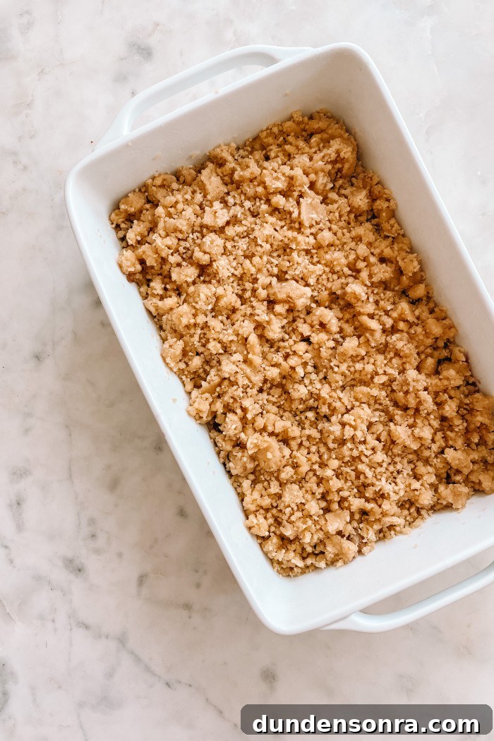 Raspberry bars with crumble on top in a white pan on a marble table