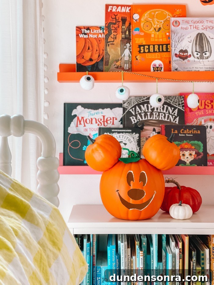 Mickey Mouse Pumpkin Carving and Decorating Guide 11 Mickey Mouse pumpkin in front of Halloween books and bookshelves next to bed
