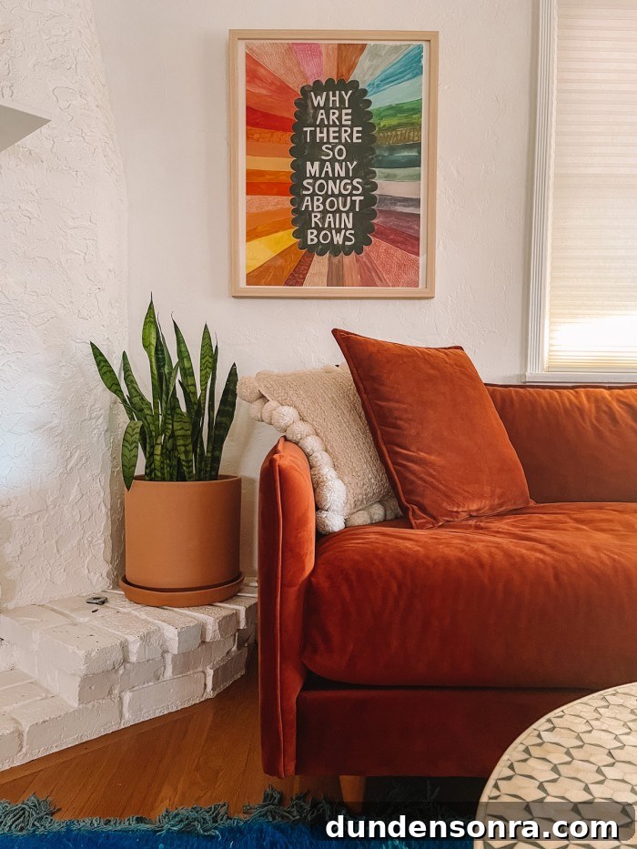 Rust sofa with rainbow art print above it