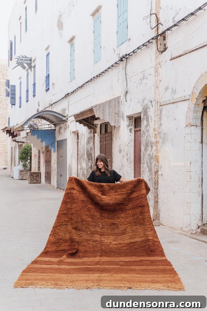 woman holding large cognac brown moroccan rug