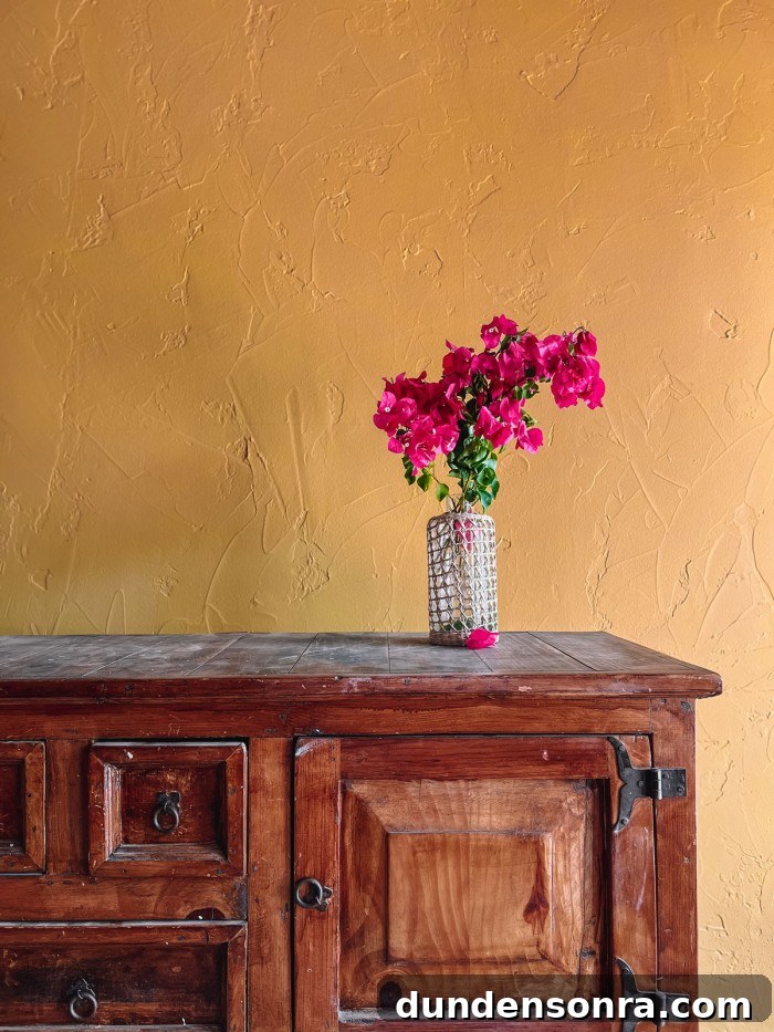 bougainvillea on wood console with ochre walls