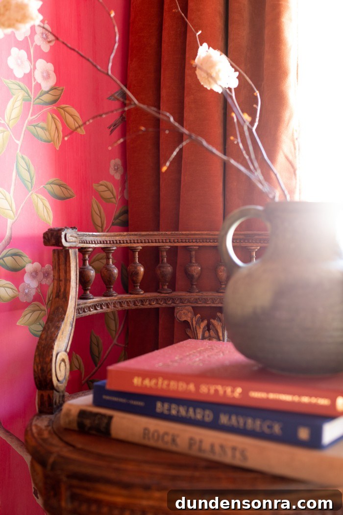 Wood chair with books stacked on top and vase with branches