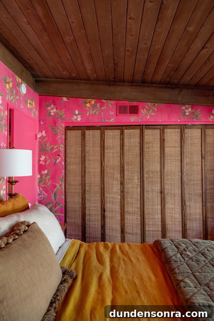rattan bifold closet doors with pink chinoiserie wallpaper and bed in front