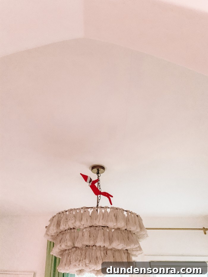 Elf on the Shelf swinging from chandelier