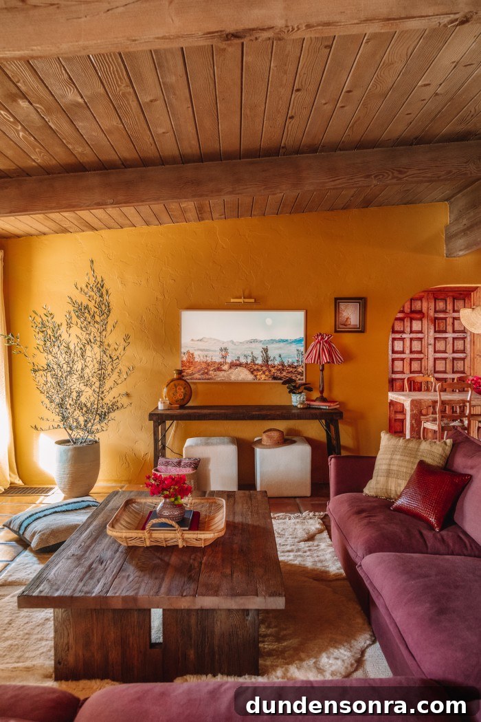 frame TV over antique table with couch in ochre living room