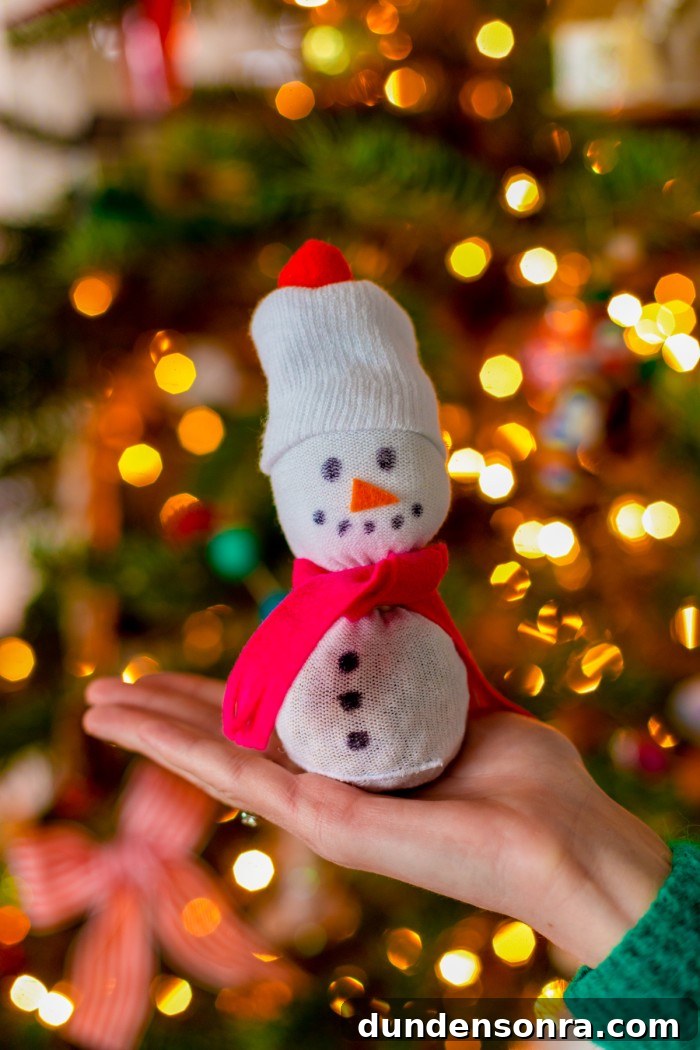 10 Family Christmas Crafts and Activities Inspired by Movies 12 Sock Snowman in front of tree
