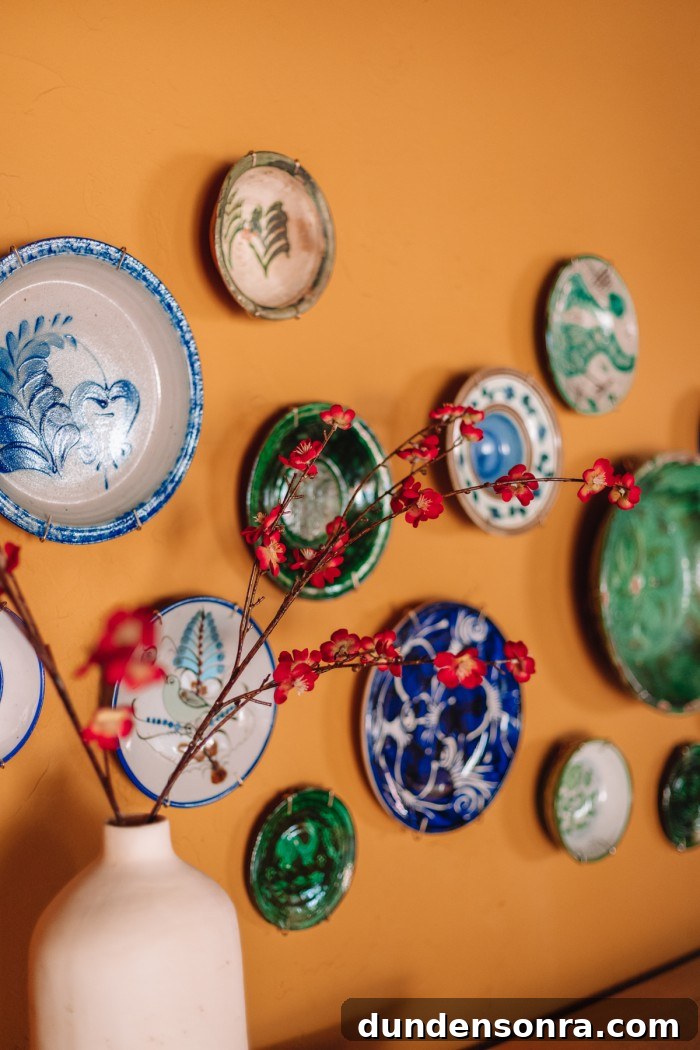 green and blue plates hanging on wall with red flowers