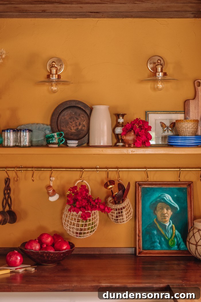 yellow kitchen with brass pot rail and portrait painting on butcher block counters