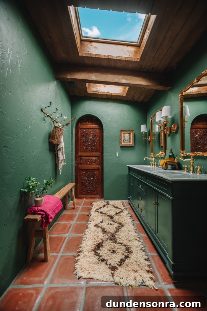 dark green bathroom with antique wood door in archway