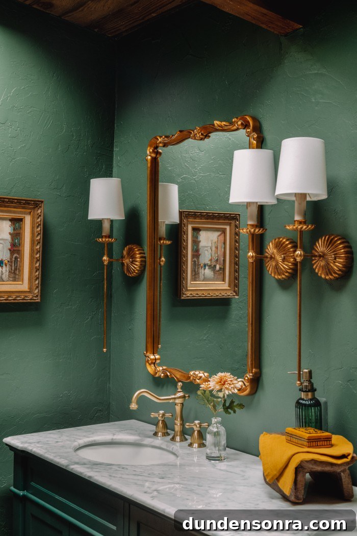green bathroom with gold mirrors and sconces