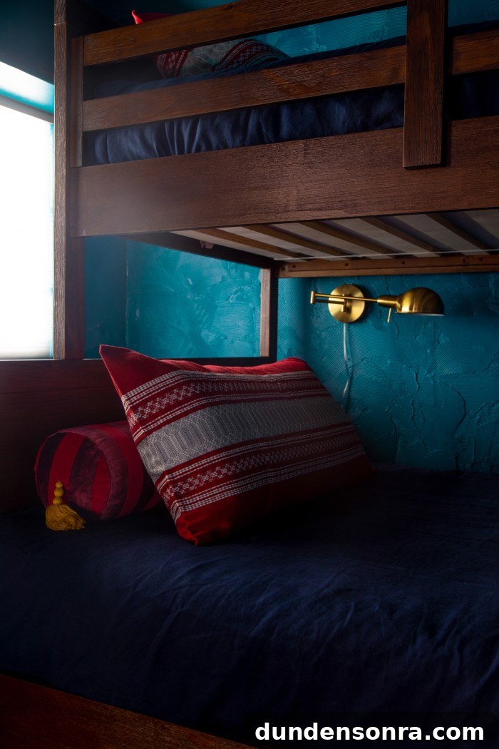 Textured Teal Bunk Room Ideas for Stylish Small Spaces 10 red pillow on bunk bed with gold reading light