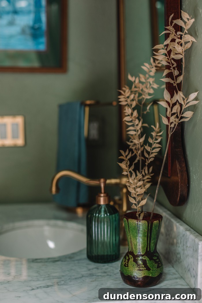 green vase on marble sink in green bathroom