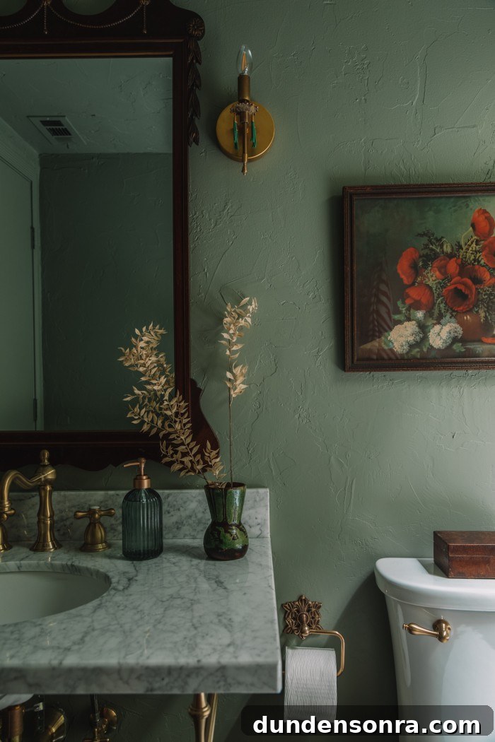 green bathroom with flower painting and tassel sconce