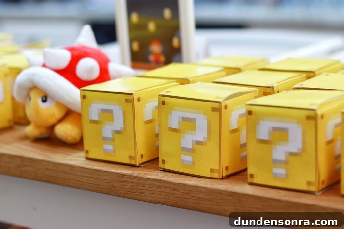 24 Super Mario Birthday Party Ideas to Wow Fans of All Ages 27 question mark box party favors stacked on a table with Spiney plush