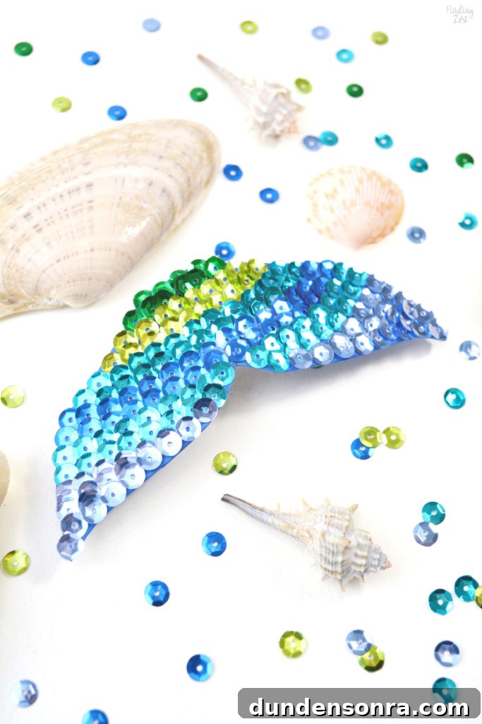 Mermaid Crafts for Kids: 25 Fun Underwater DIY Ideas 11 Mermaid fin hair clip on a table with sequins