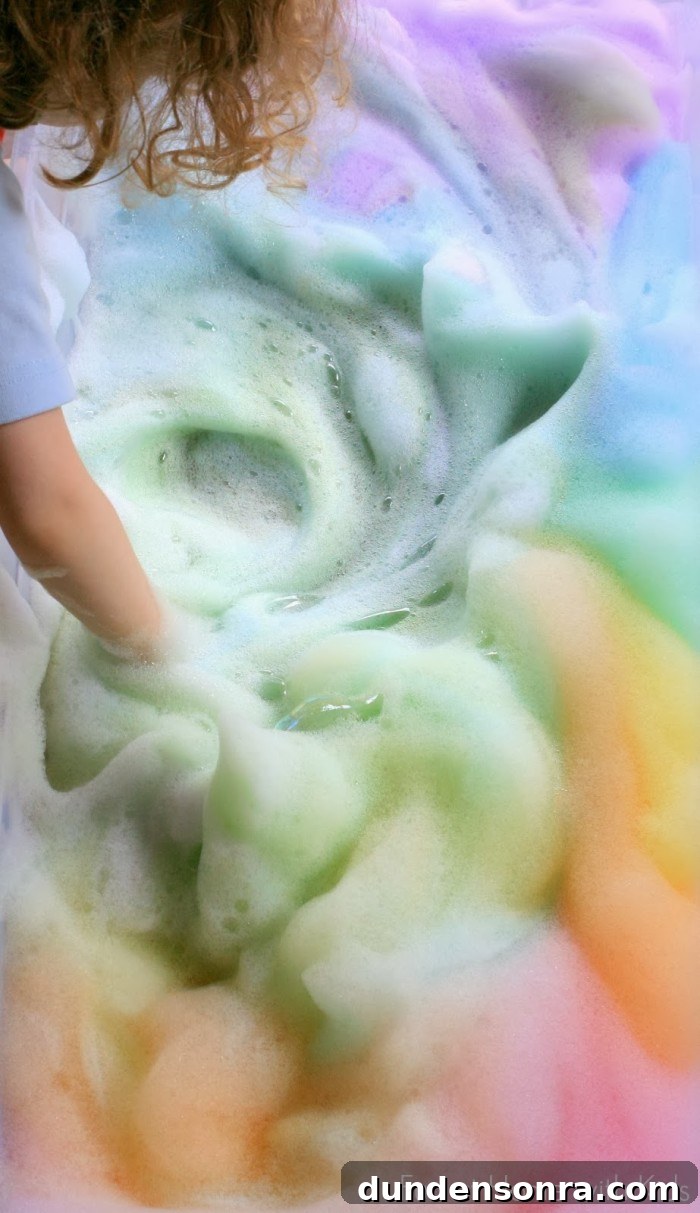 Rainbow foam bubbles swirled by a child. 
