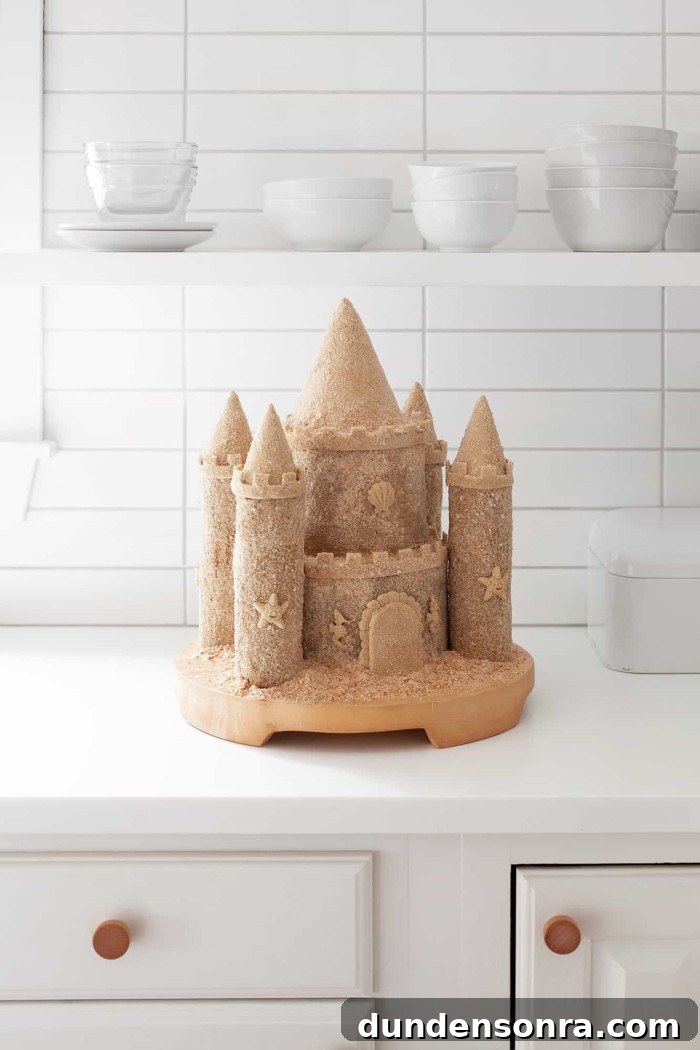 Sandcastle cake on a stand on the counter. 