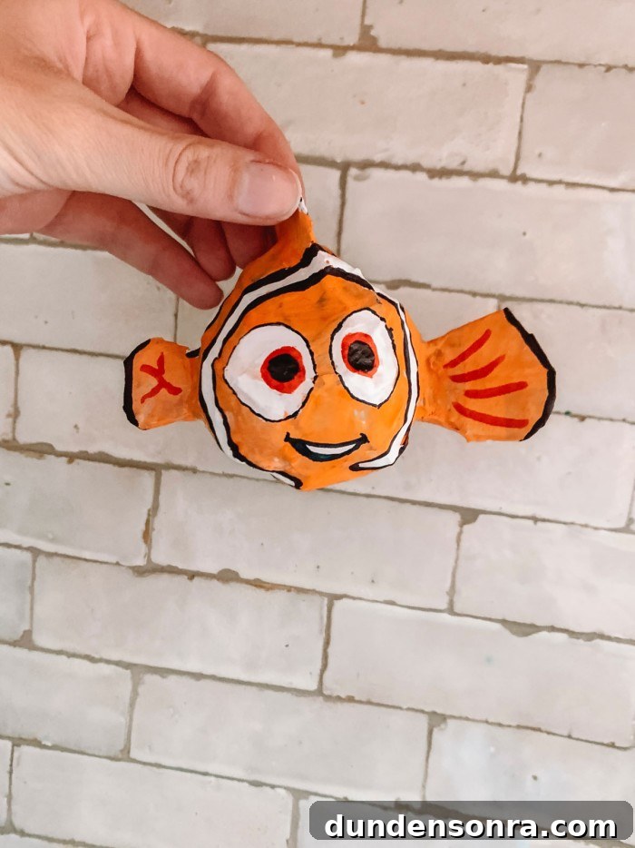 paper mache Finding Nemo held in front of a Tile wall