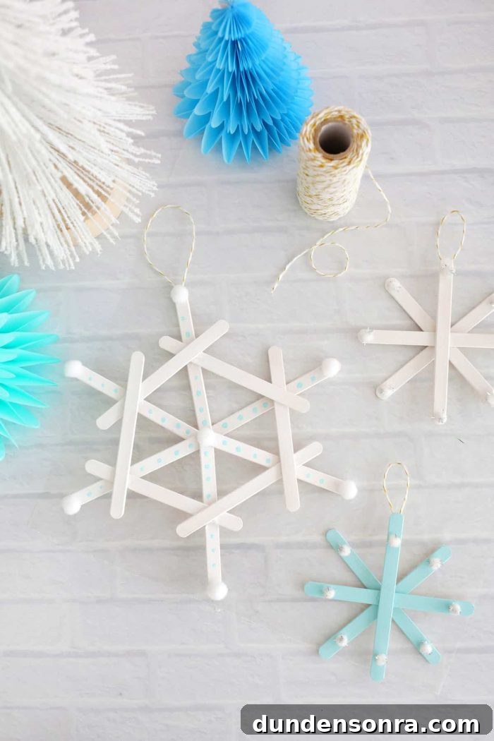 Handmade Christmas Ornaments Kids Can Make at Home 14 Popsicle stick snowflake ornaments on a brick background.