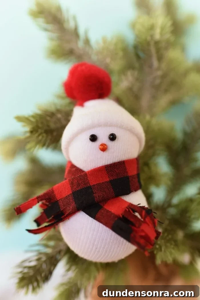 Handmade Christmas Ornaments Kids Can Make at Home 22 Snowmen ornaments hanging on a tree.