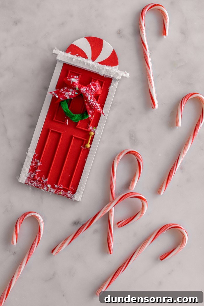 mini elf door laying on table with candy canes