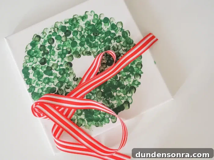 Handmade Gift Ideas Grandparents Will Cherish 13 Fingerprint wreath on a canvas with a red ribbon on top.