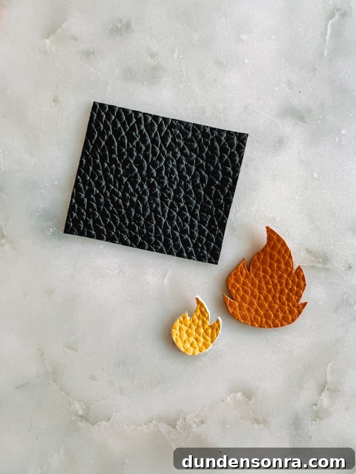 black rectangle and fire pieces cut out of leather on marble