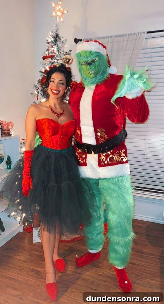The Grinch Christmas Costumes Two people dressed up as the Grinch and Martha May standing in front of a Christmas tree.