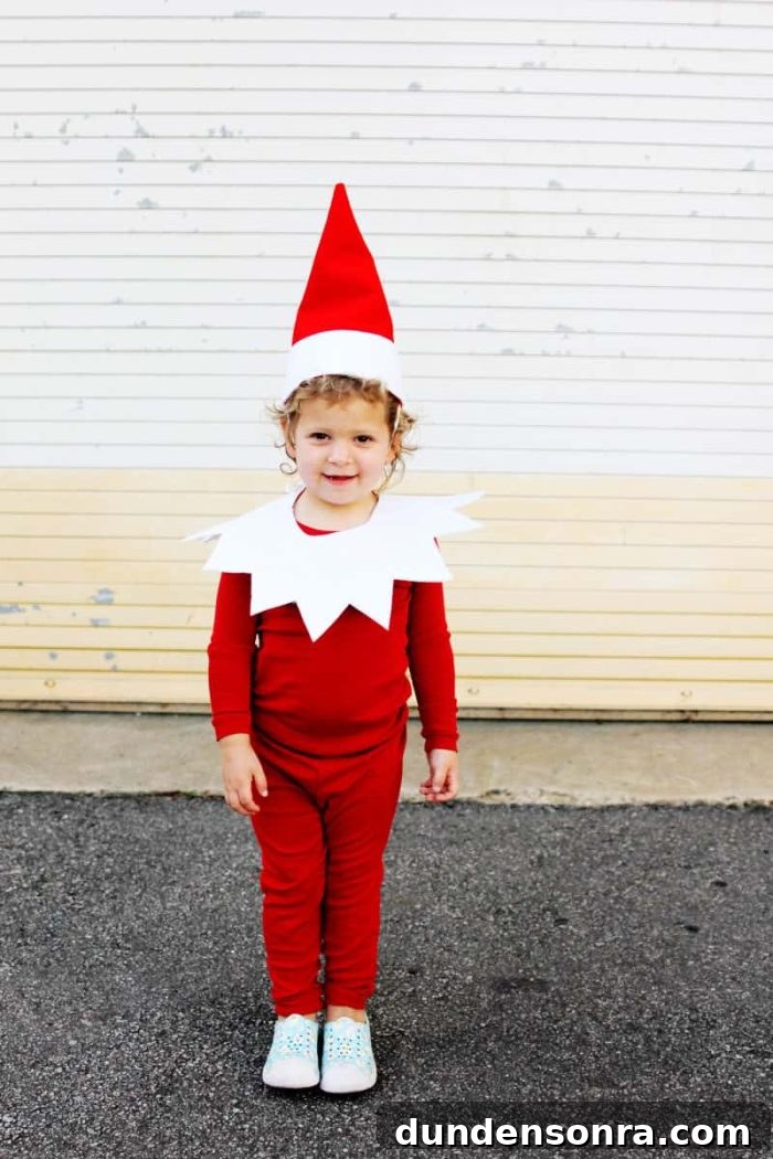 Elf on the Shelf Christmas Costume Child wearing a red outfit that looks like Elf on the Shelf.